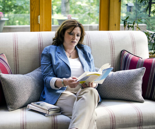 Dolly Ford-Sullivan, West Virginia Life Coach, on couch with book